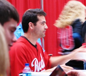 Votto handing a kid his autographed item.