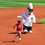 A kid flying by the Goodyear mascot during a between-innings contest A kid flying by the Goodyear mascot during a between-innings contest