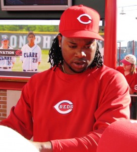 Johnny Cueto hands a fan's hat back after signing it