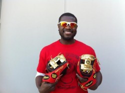 Brandon Phillips holding 2 gold-colored baseball gloves