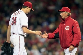 Homer Bailey hands over the ball to acting manager Chris Speier. (AP Photo/Al Behrman)
